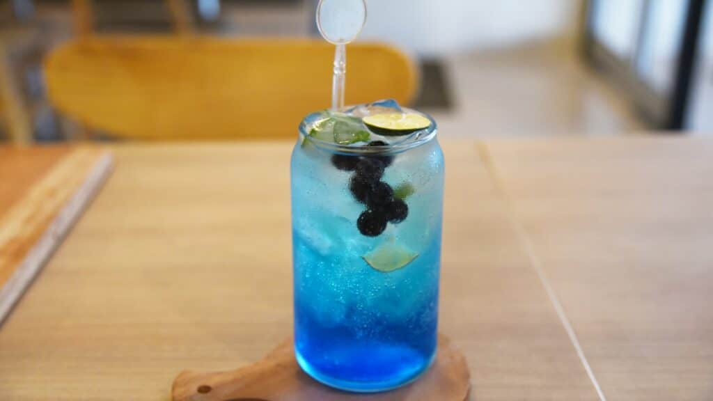 a blue drink with a lime slice in it