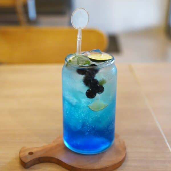 a blue drink with a lime slice in it
